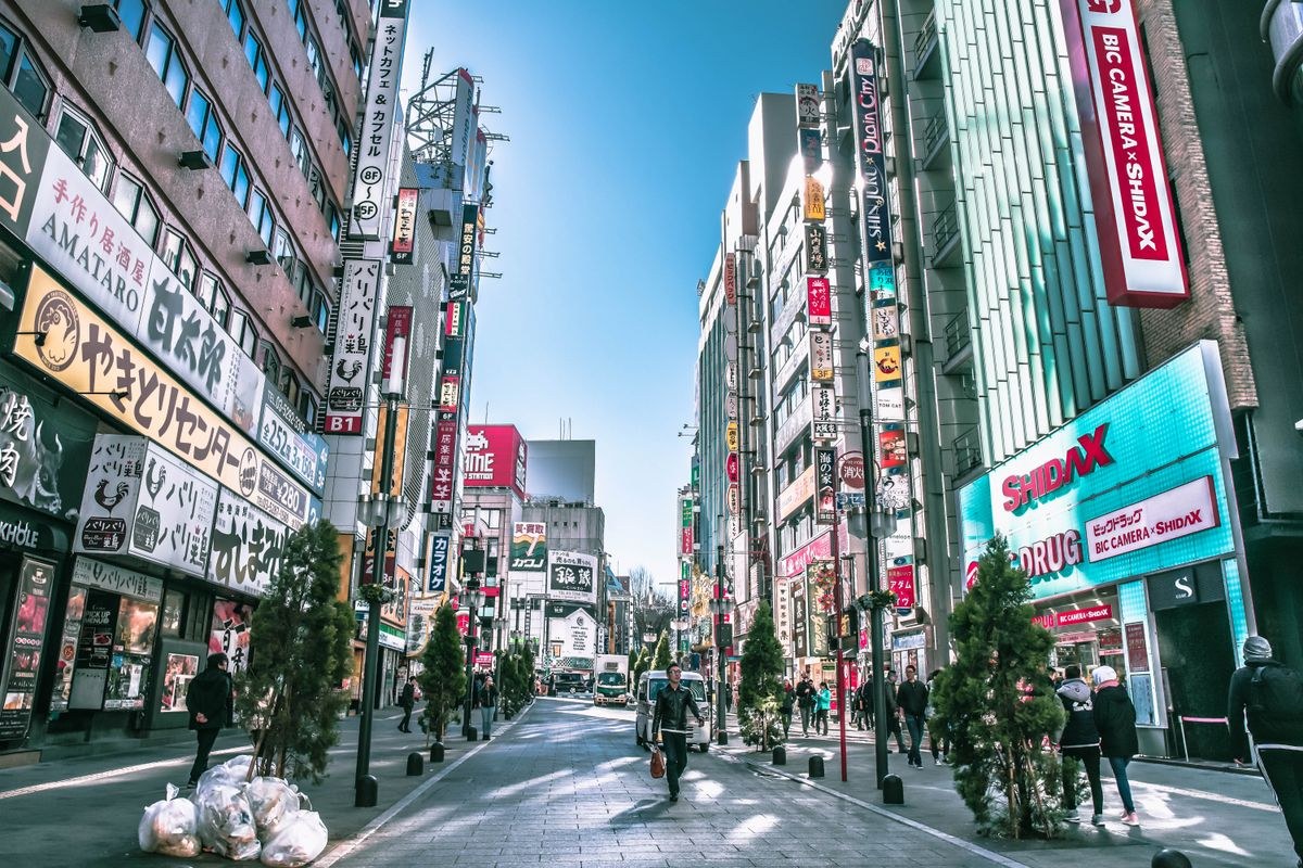 Lively street scene in Tokyo showcasing busy streets, people, and vibrant signs.